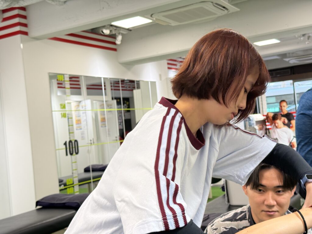 お客様の身体の状態を確認しながらストレッチを行うトレーナー