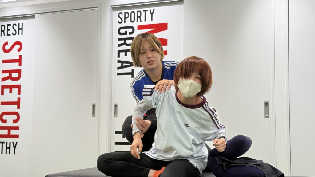 お客様とコミュニケーションを取るストレッチトレーナー